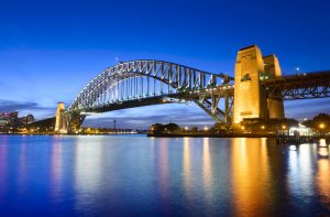 Sydney Harbour Bridge at twilight with reflection in the still water, clear blue sky, Australia.
